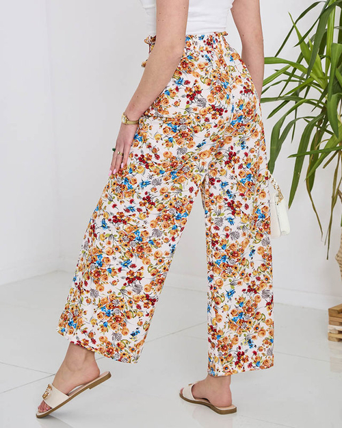Жіночі білі штани палаццо з помаранчевими квітами - Одяг